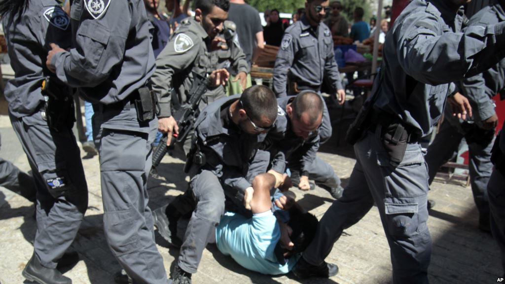 Israelilaispoliisit palestiinalaisen kimpussa.