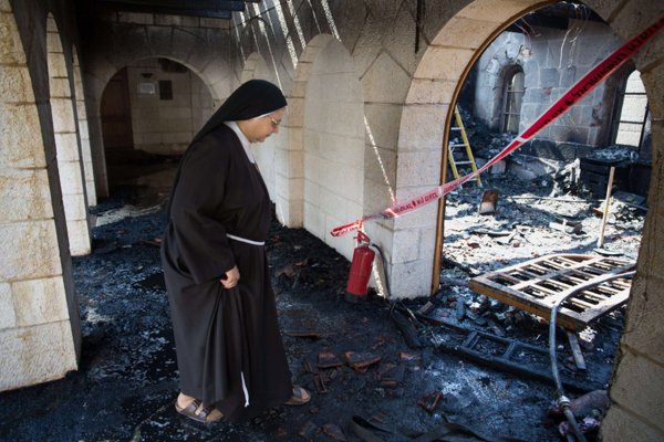 Juutalaisten polttaman kirkon raunioilla Israelissa.