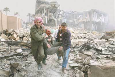 Miehet kantavat haavoittunutta Irakissa.