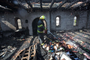 Jälkisammutus käynnissä juutalaisten polttaman kirkon raunioilla, Israelissa.
